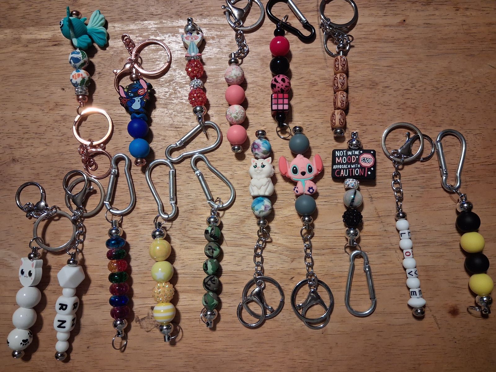Colorful beaded keychains with metal rings, clips, animal charms, and patterned beads