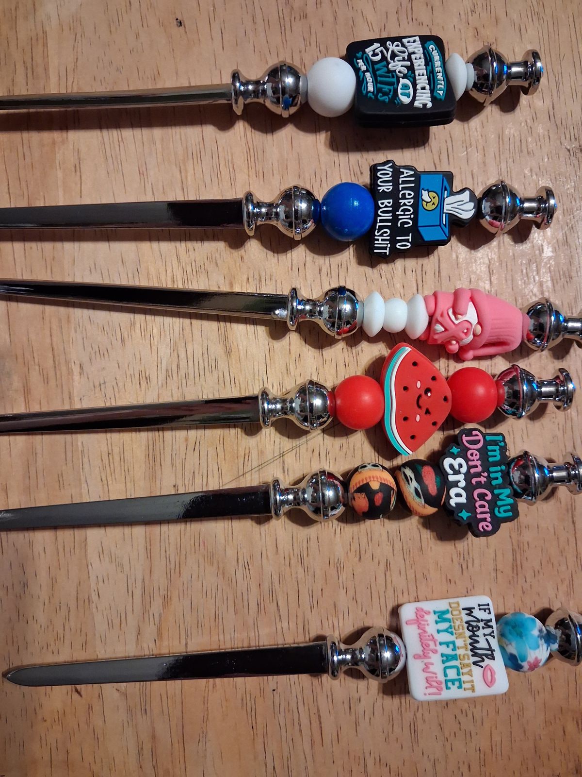Silver letter openers with colorful beaded handles and decorative character and word charms