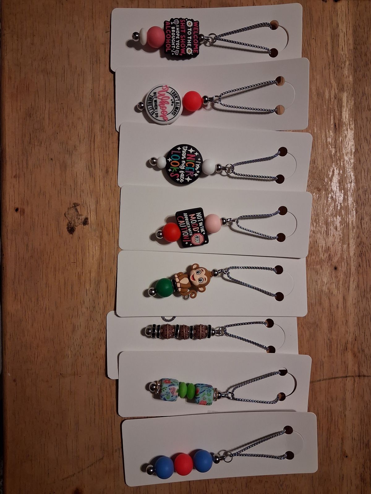 Beaded pendant necklaces on white display cards, with colorful beads, patterned beads, and decorative charms