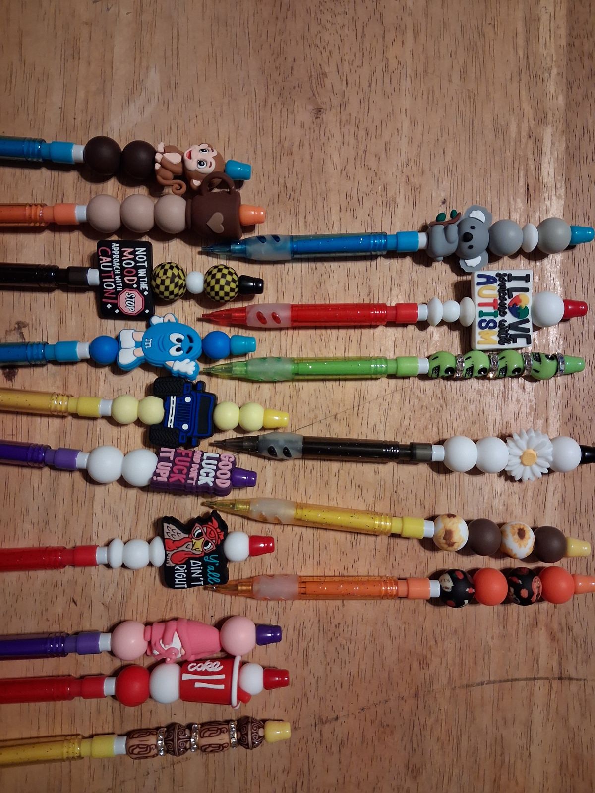 Colorful pencils with beaded tops, animal and flower charms, and decorative word charms