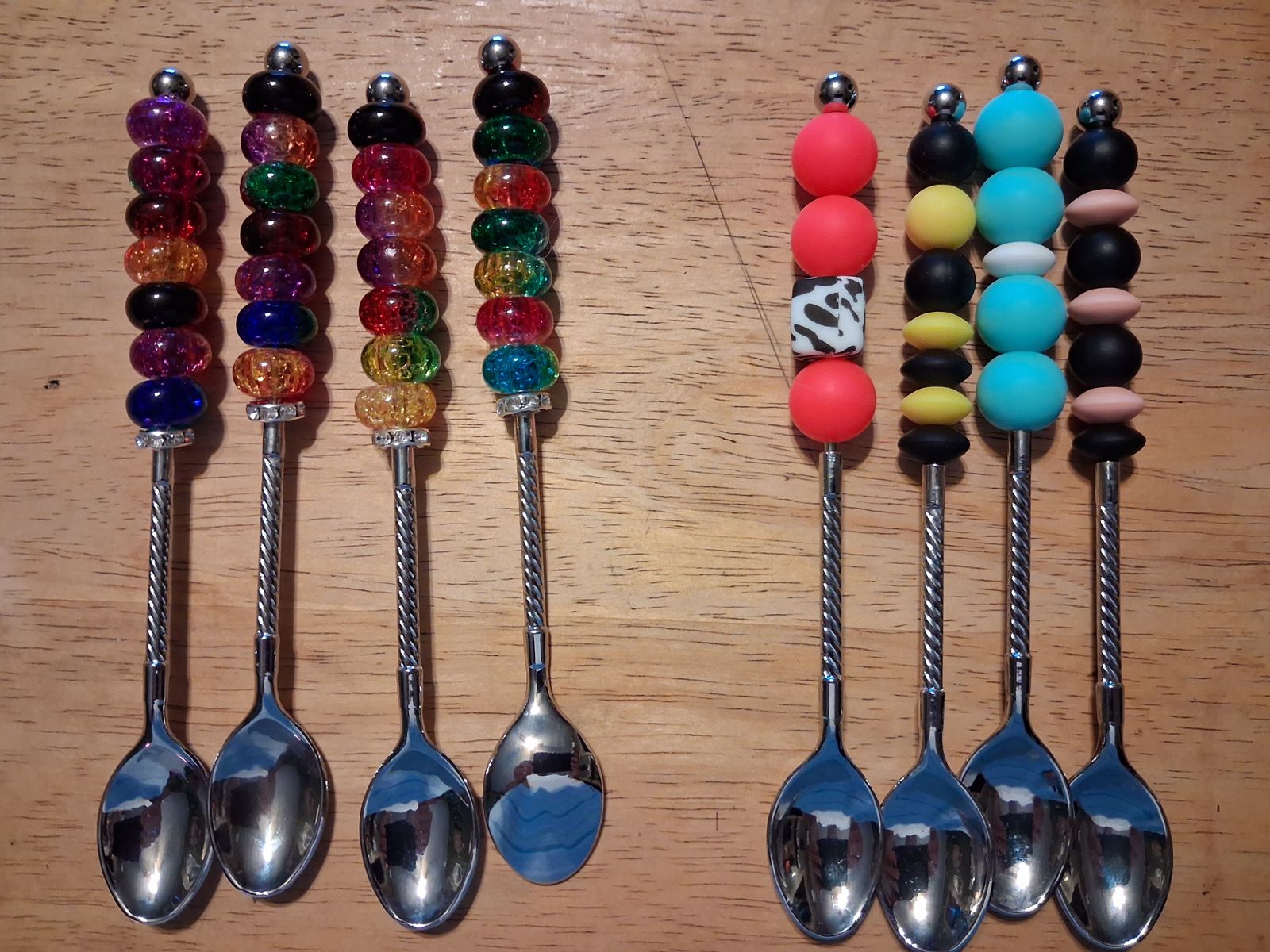 Silver teaspoons with colorful beaded handles in rainbow, turquoise, red, yellow, and black designs