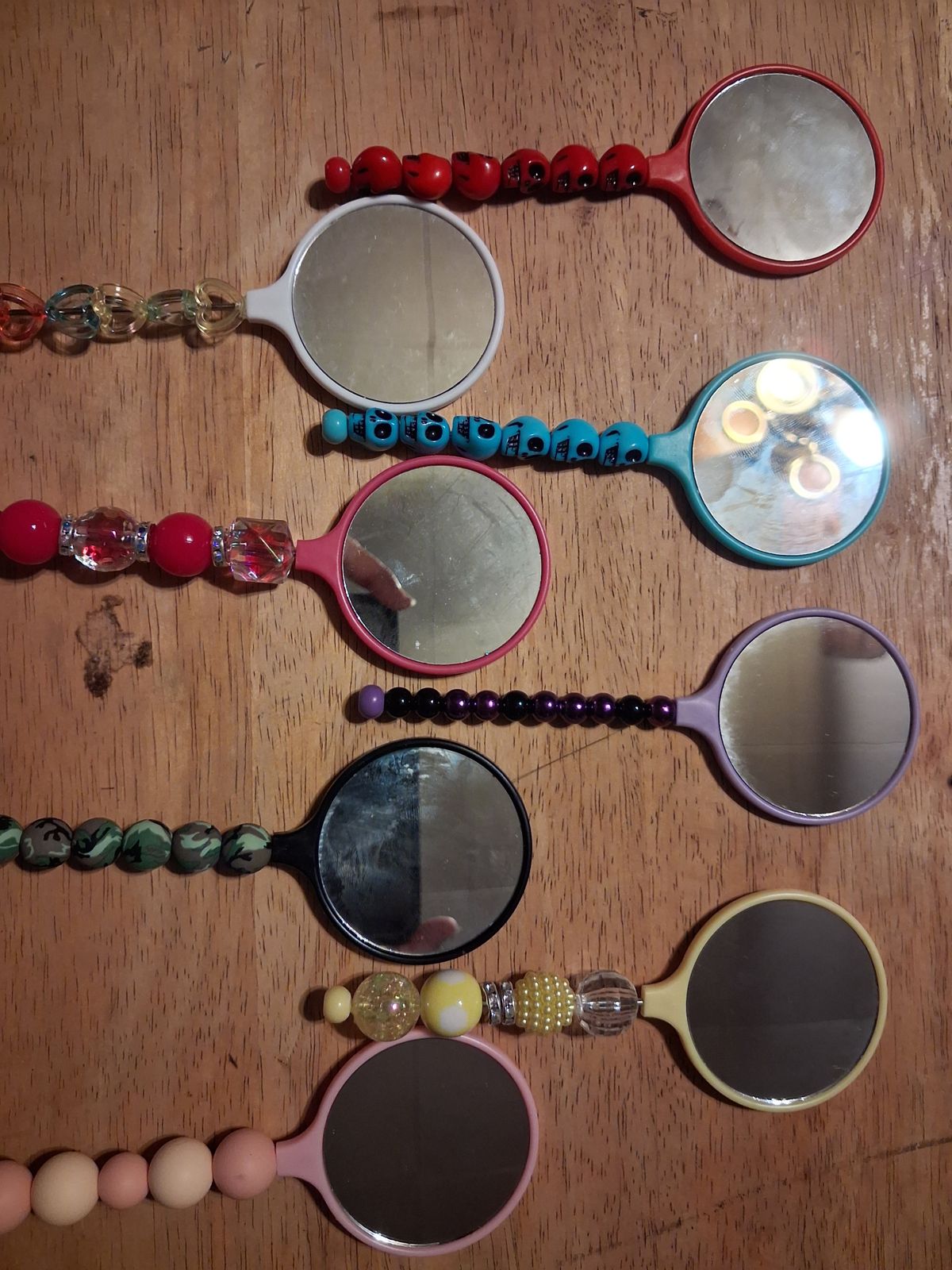 Mini handheld mirrors in different colors with colorful beaded handles