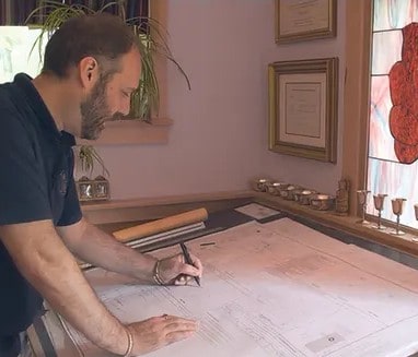 Talor Stewart drawing a home floor plan at his studio table