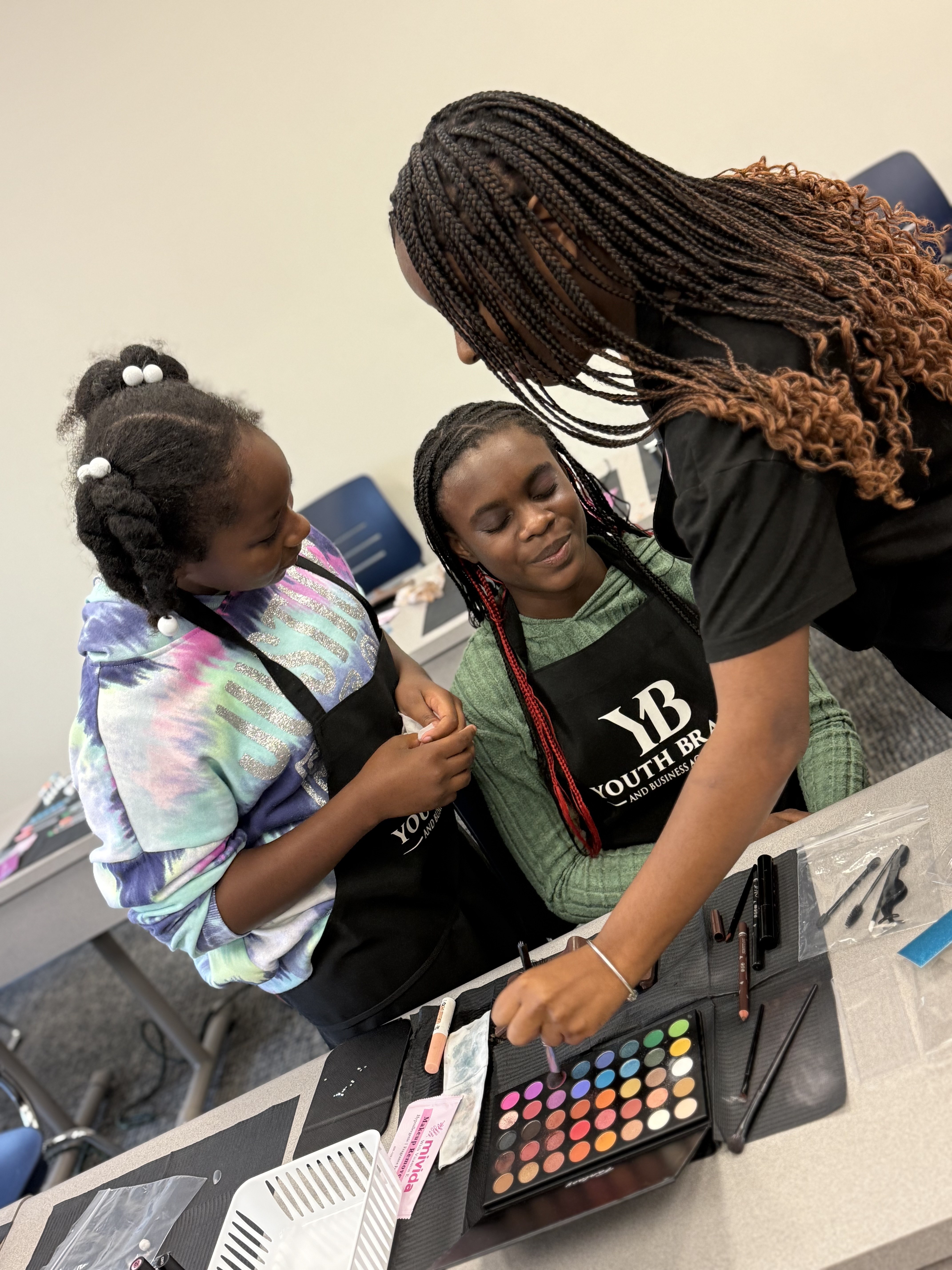 Youth Braid and Business Academy instructor supporting a student during a lesson