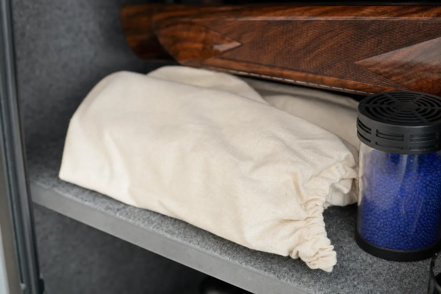 A cotton protective storage sleeve on a safe shelf beside a moisture-control container