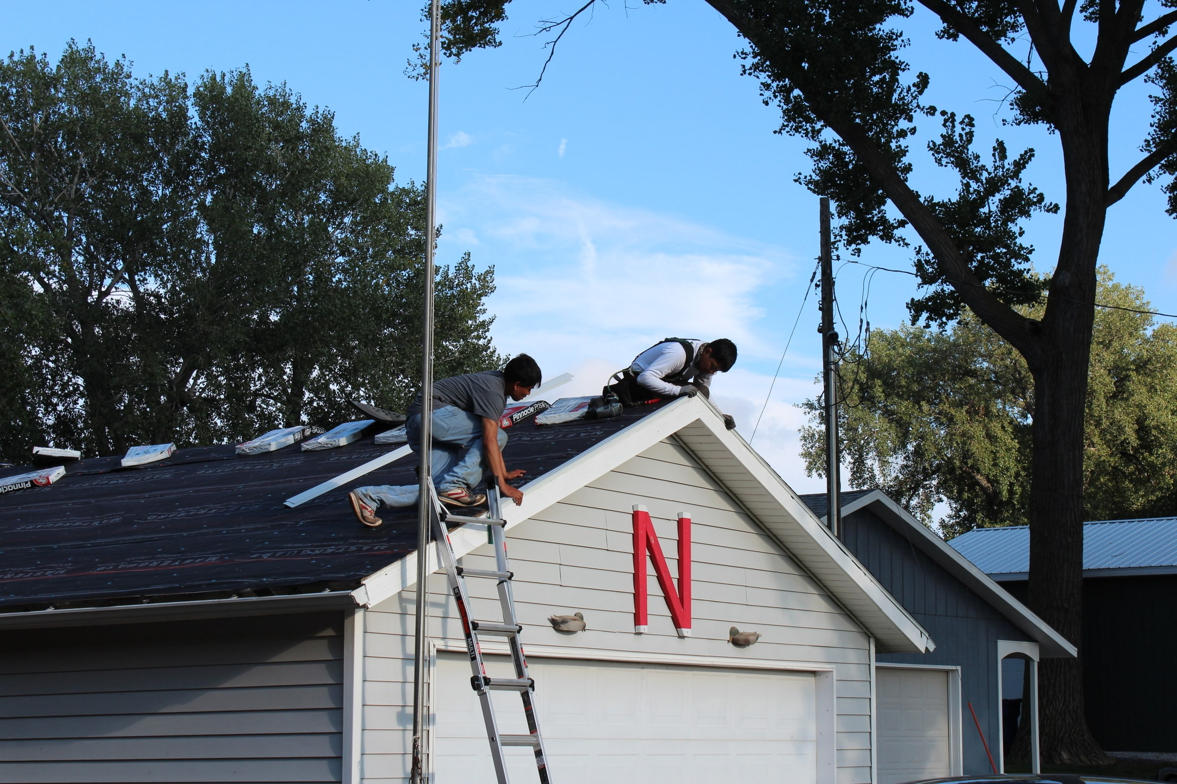 Roofing crew installing shingles on a residential home