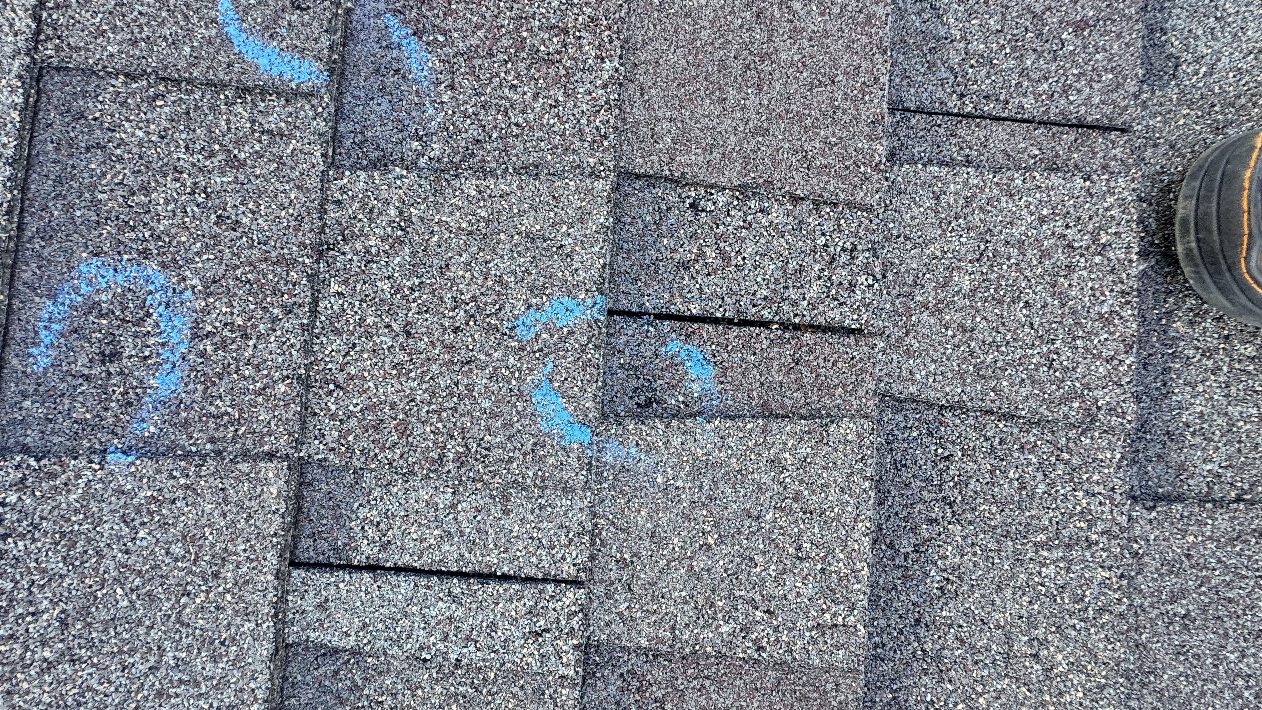 Close roof inspection identifying shingle damage