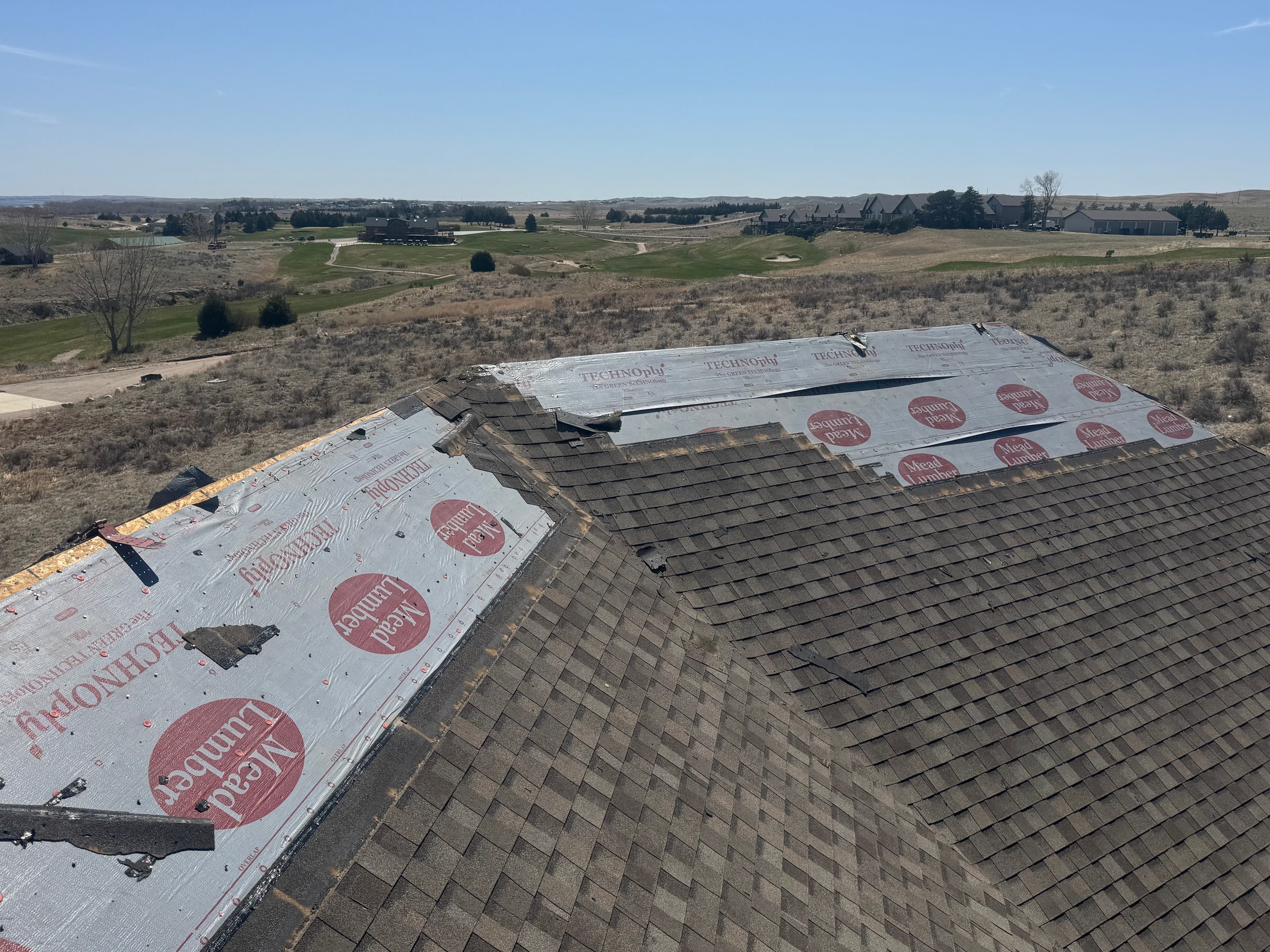Roof replacement in progress with underlayment and new shingles
