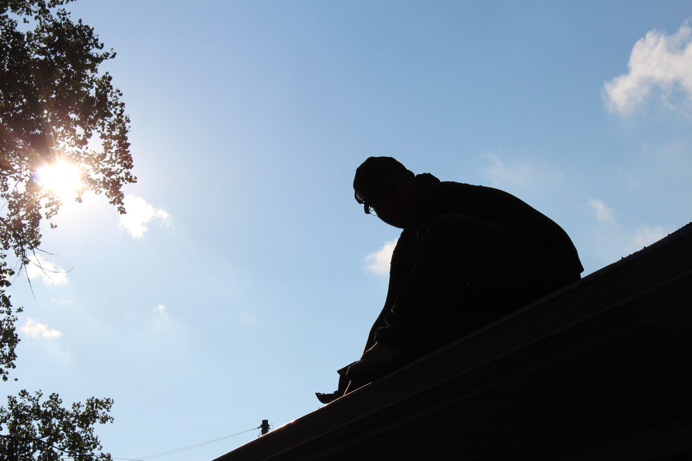 Roofer working at a residential roof ridgeline