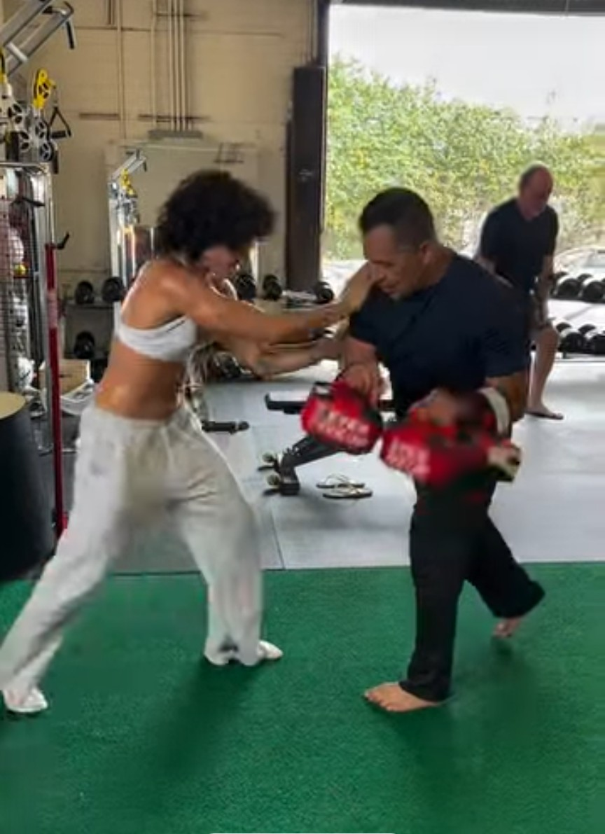 Vinny Cruz giving a client hands-on coaching during a gym self-defense session