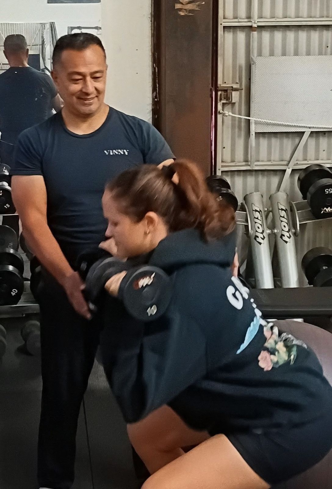 Vinny Cruz guiding a client through a strength exercise