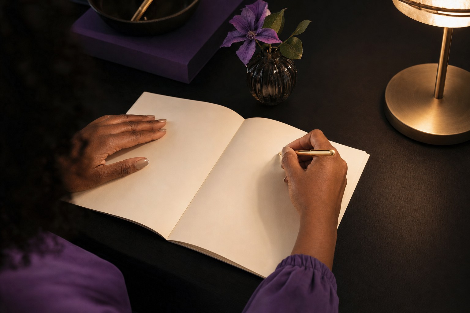 Hands writing goals in an open planning workbook