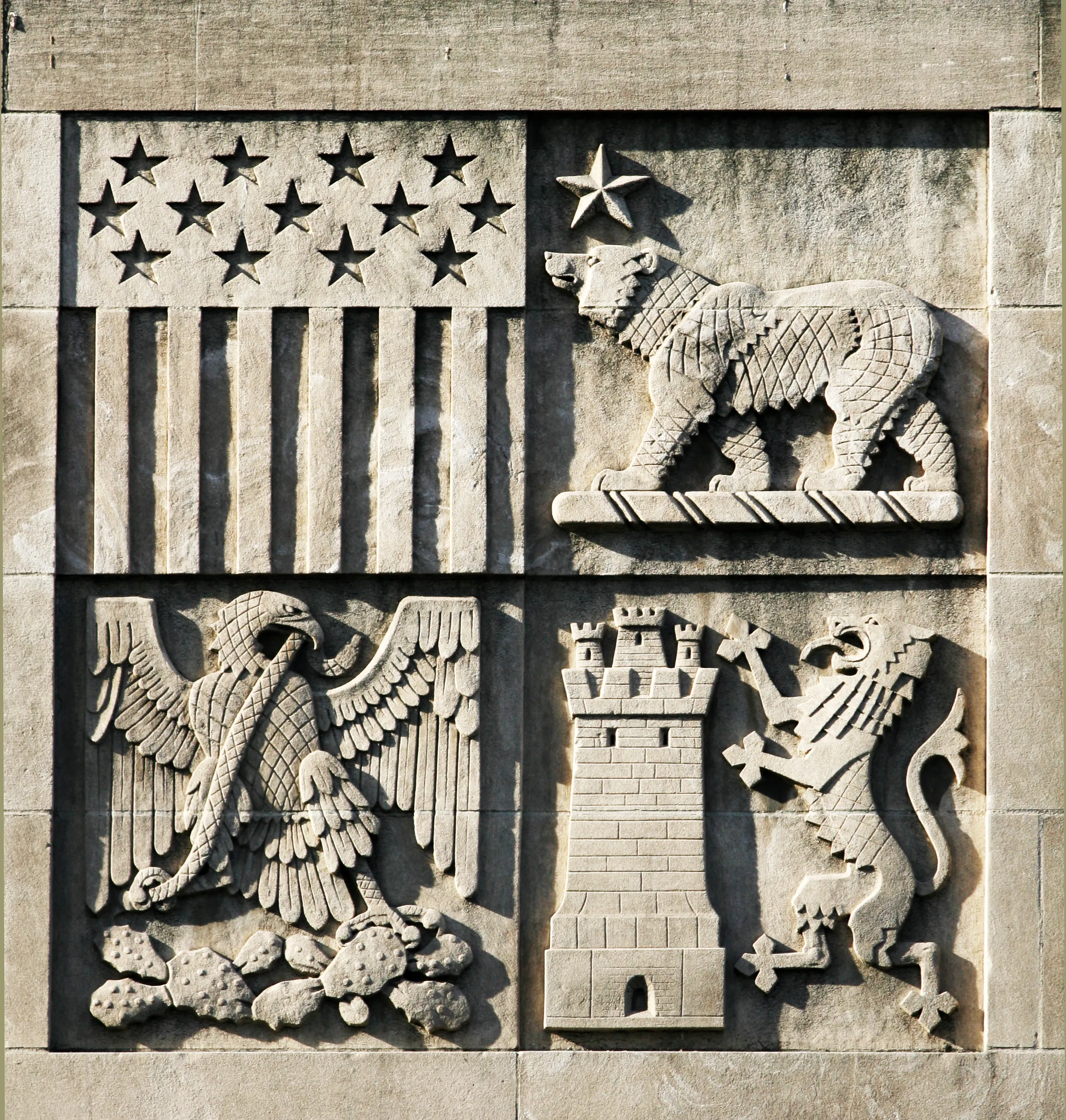 Photograph of Library’s Coat of Arms, Close detail of the carved American flag motif, California bear, Mexican eagle on a cactus with a snake, and English lion and castle., from Lee Lawrie’s Los Angeles, California collection.