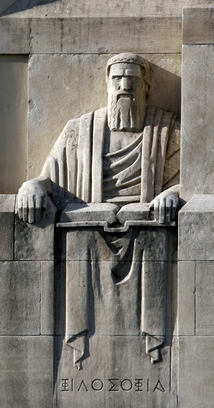 Photograph of The Philosopher, Close view of the seated stone figure at the north entrance, holding an open book., from Lee Lawrie’s Los Angeles, California collection.