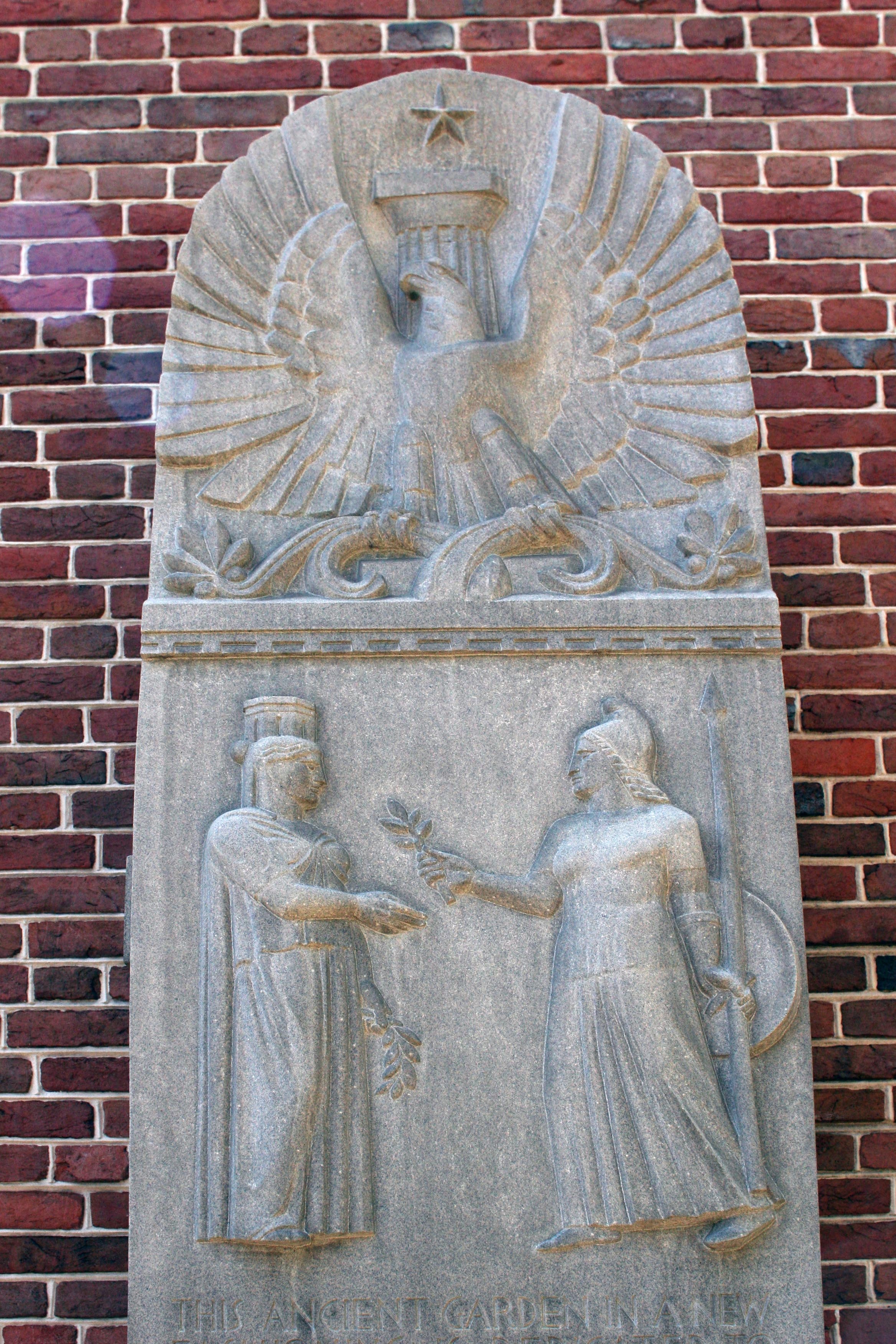 Two female figures beneath the eagle on the World War II Architects’ Monument.