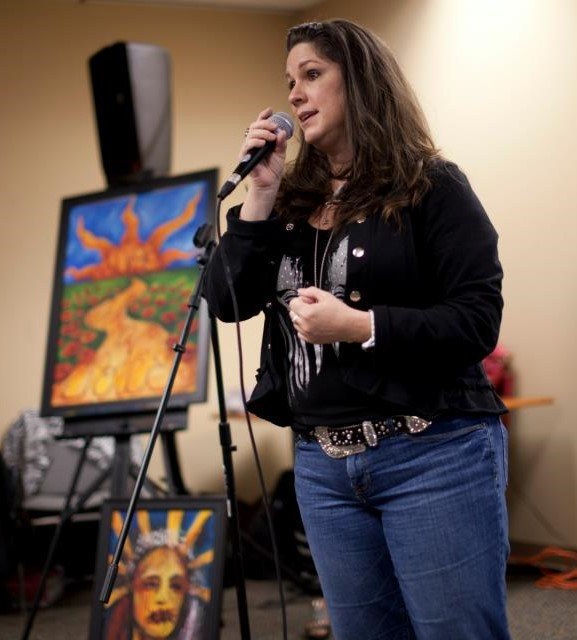 Michelle Johnson Fairchild speaking beside her artwork