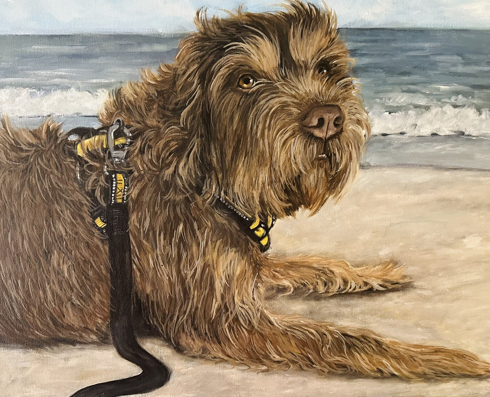 Brown doodle portrait on a beach against a soft pale background