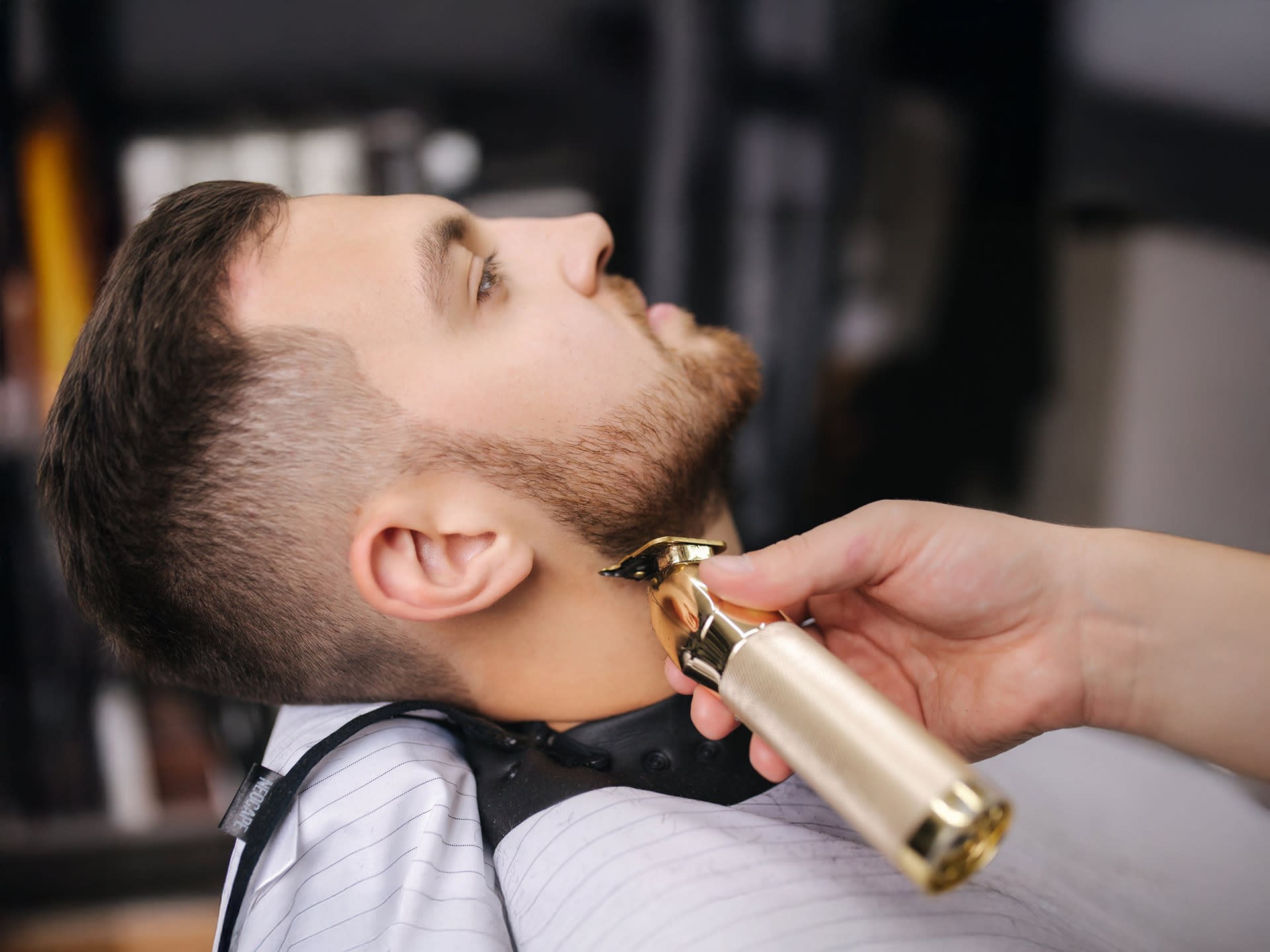 Barber grooming a client’s beard