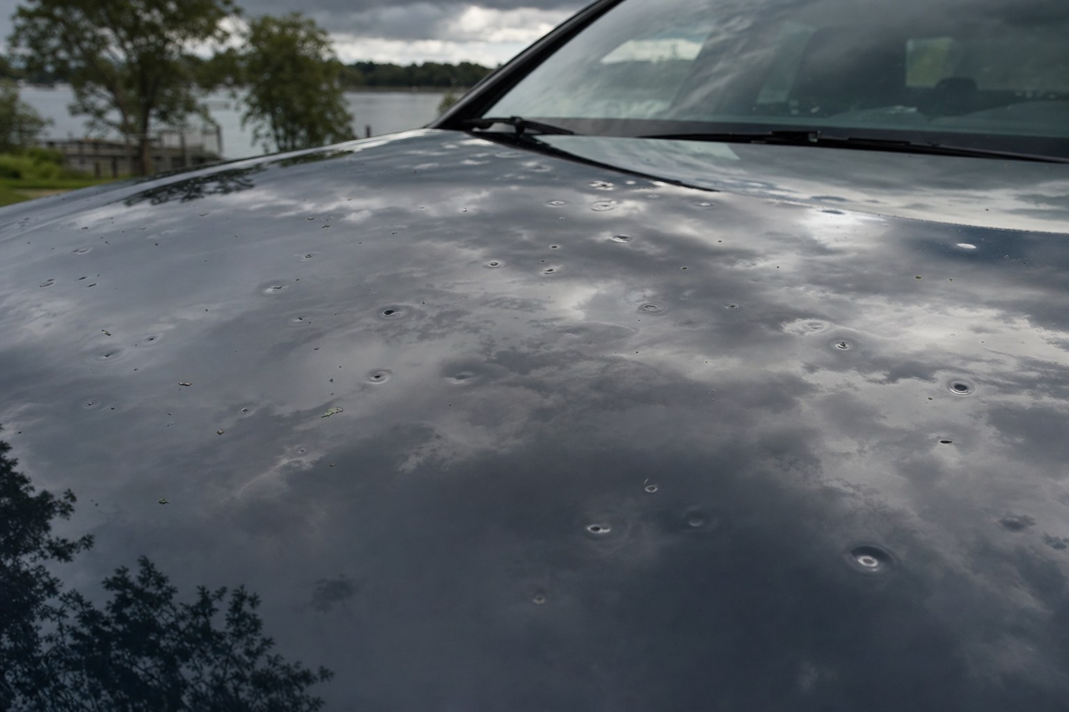 Hail dents visible across a dark vehicle hood