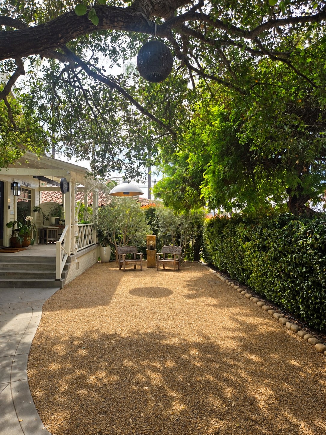 Shaded courtyard with seating beneath the trees at Islay Gardens