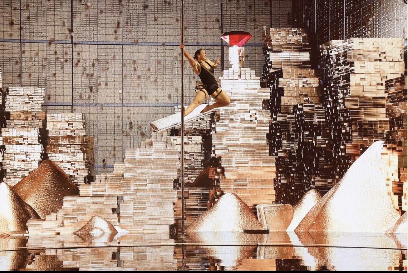 Kristy Sellars performing on pole in a gold stage world
