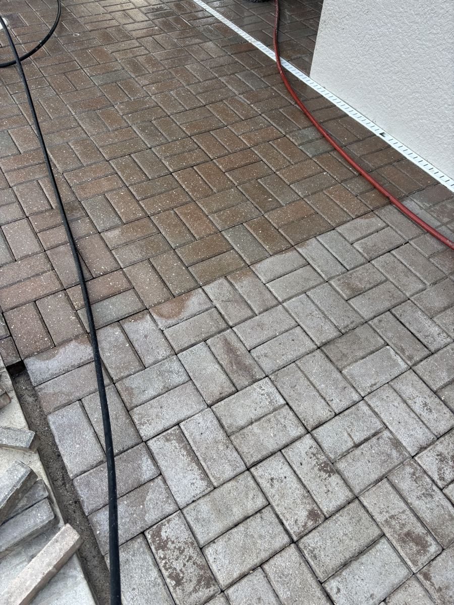 Herringbone pavers with a darker freshly treated section next to a worn, chalky, faded section in Fort Myers, FL