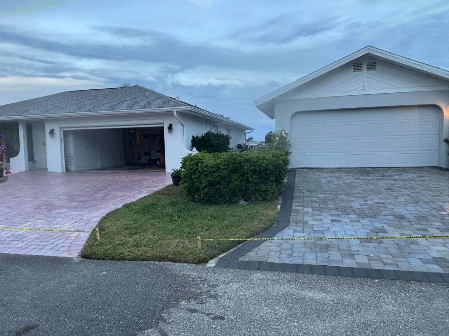 Adjacent paver driveways outside two homes under an overcast sky