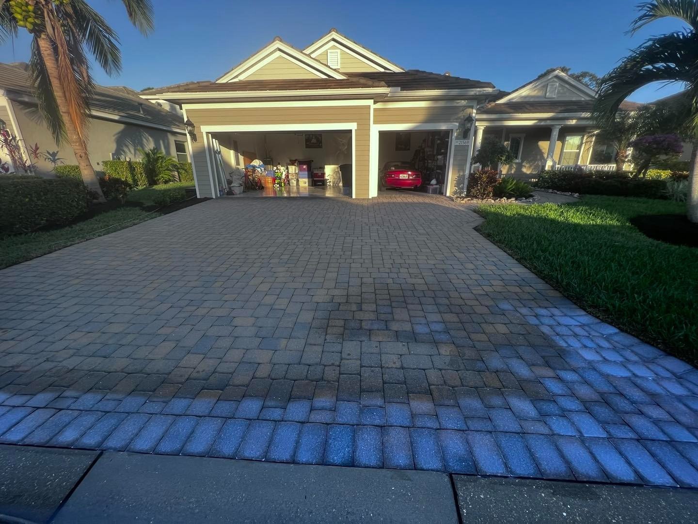 Dark paver driveway with a lighter border outside an open garage