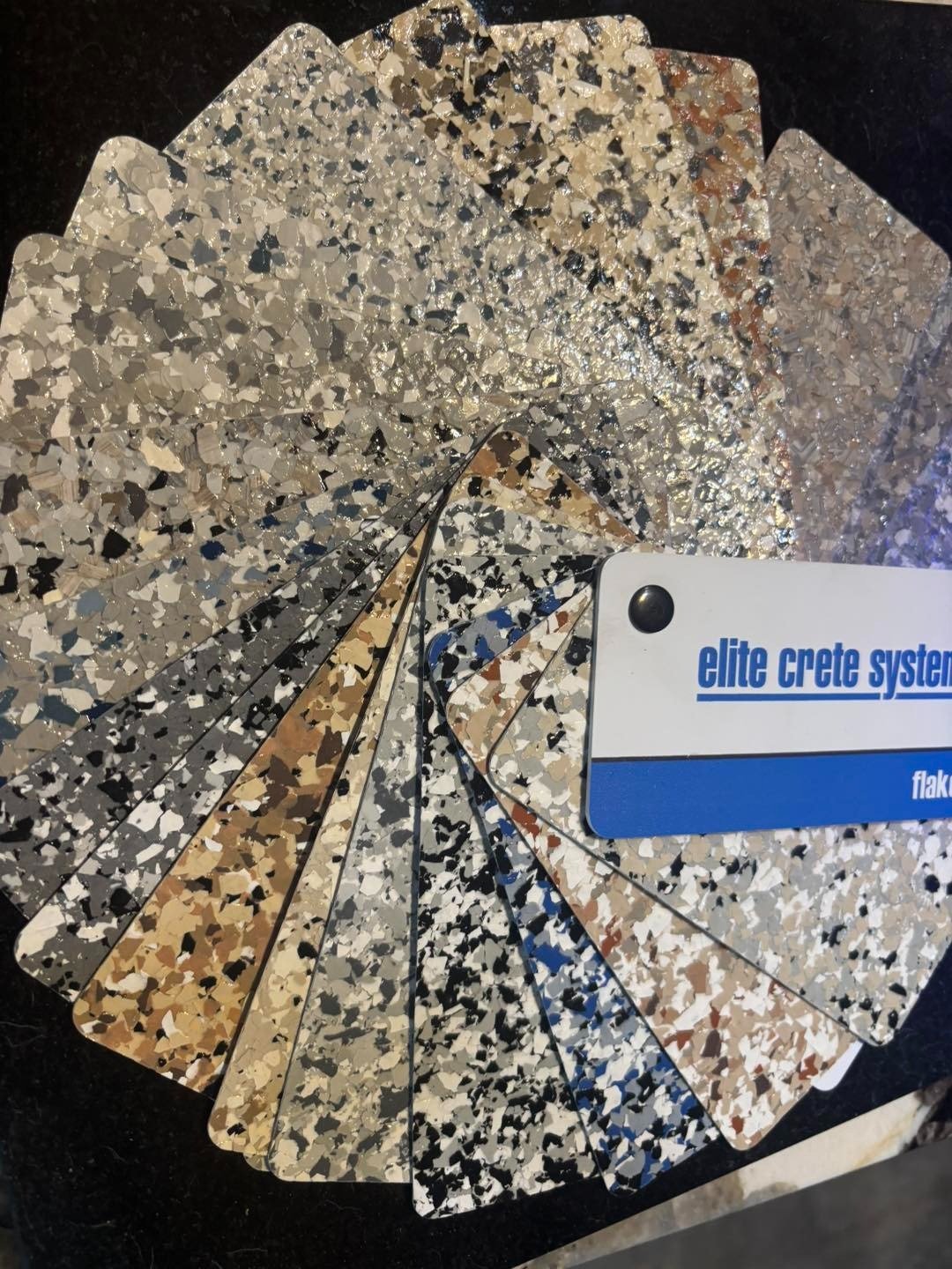 Fan of decorative floor finish samples in neutral colors