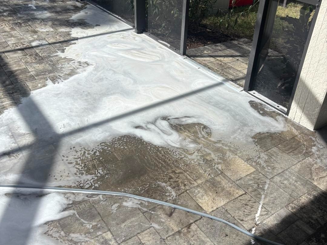 White foam covering sections of a paver patio beside sliding glass doors