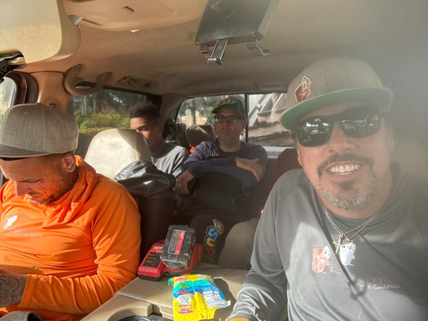 Four crew members seated together inside a work vehicle