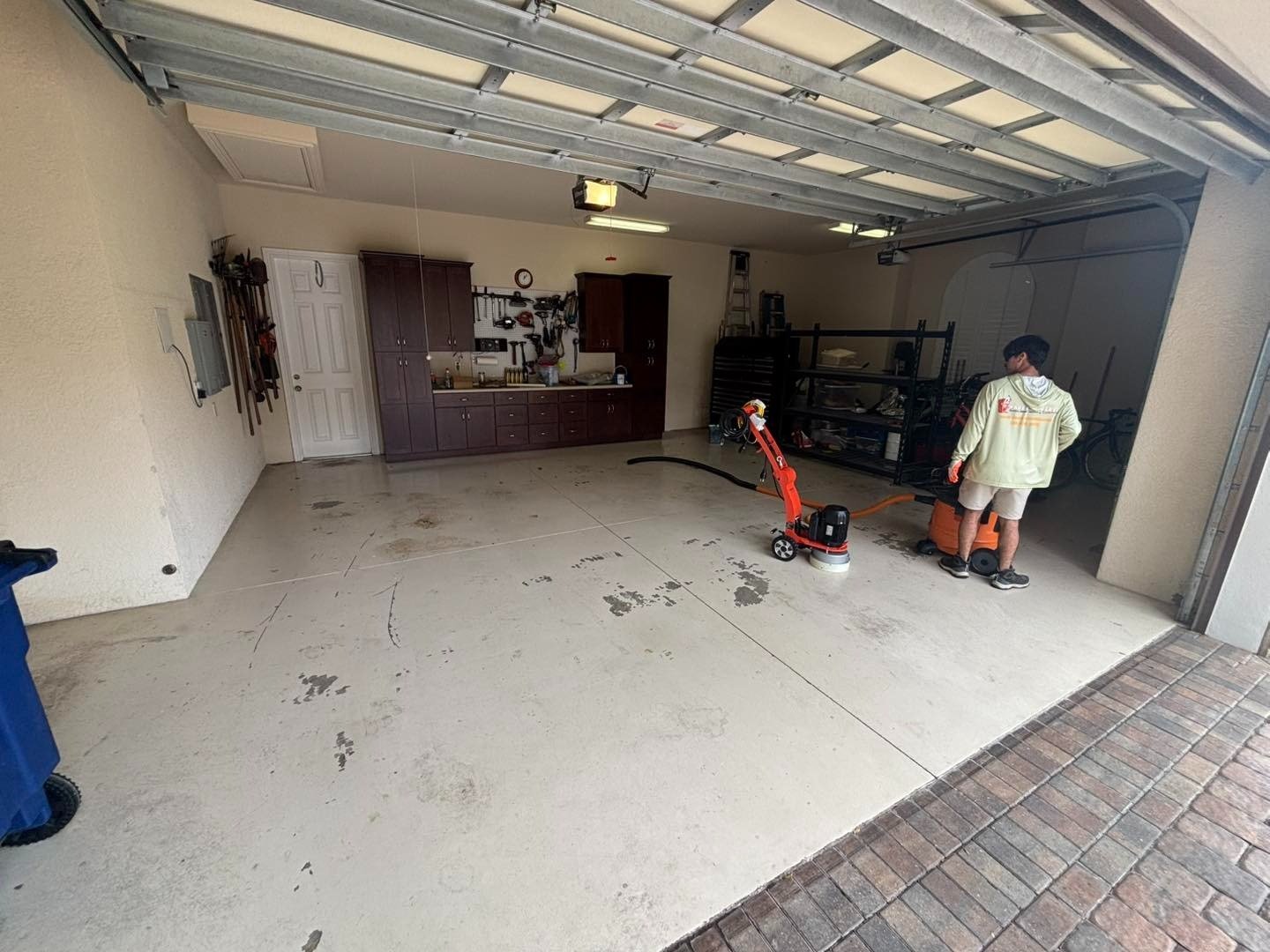 Garage with bare floor, preparation equipment, and a worker