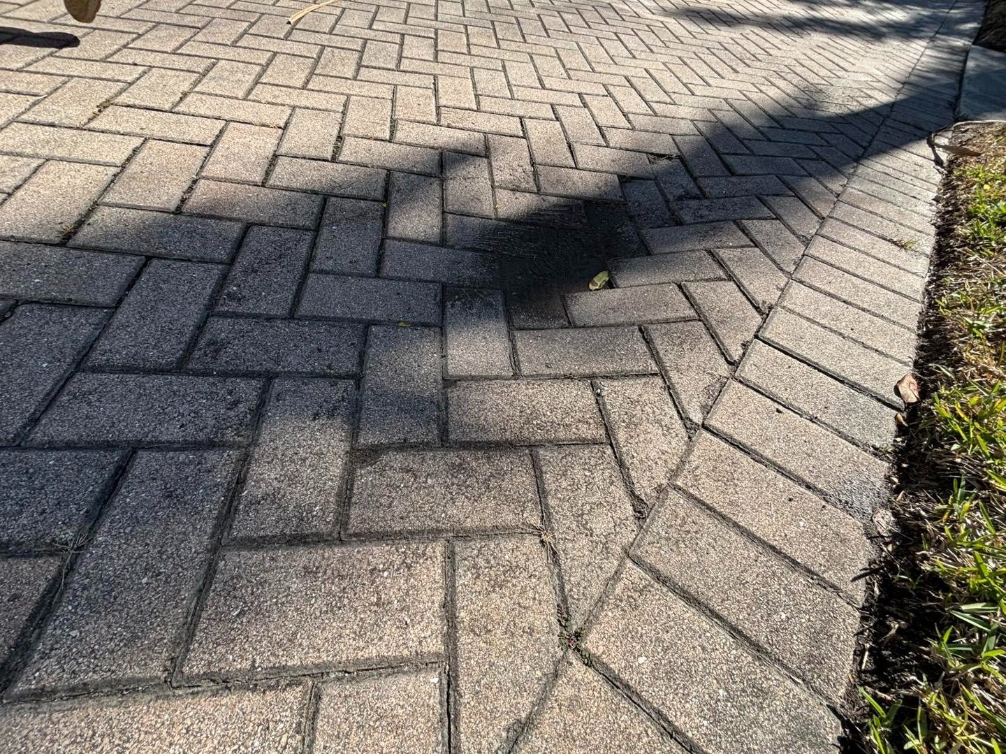 Close view of gray herringbone driveway pavers with curved border