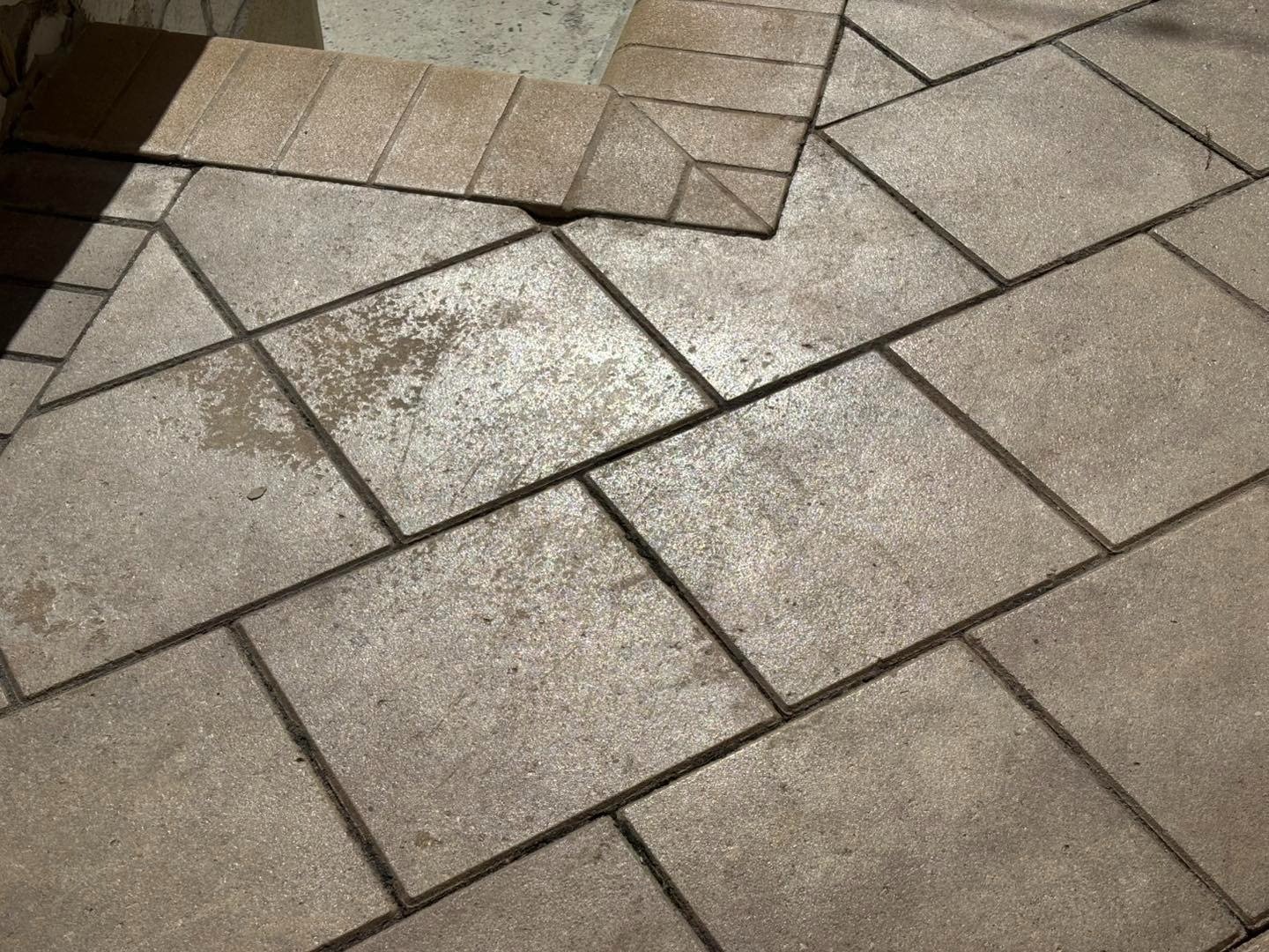 Gray patterned paving with dark joints and a diagonal border