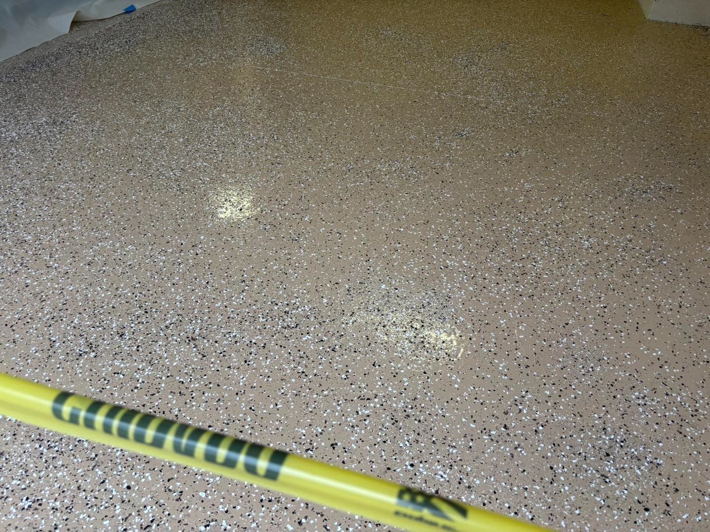 Gray speckled garage floor with caution tape across the entrance