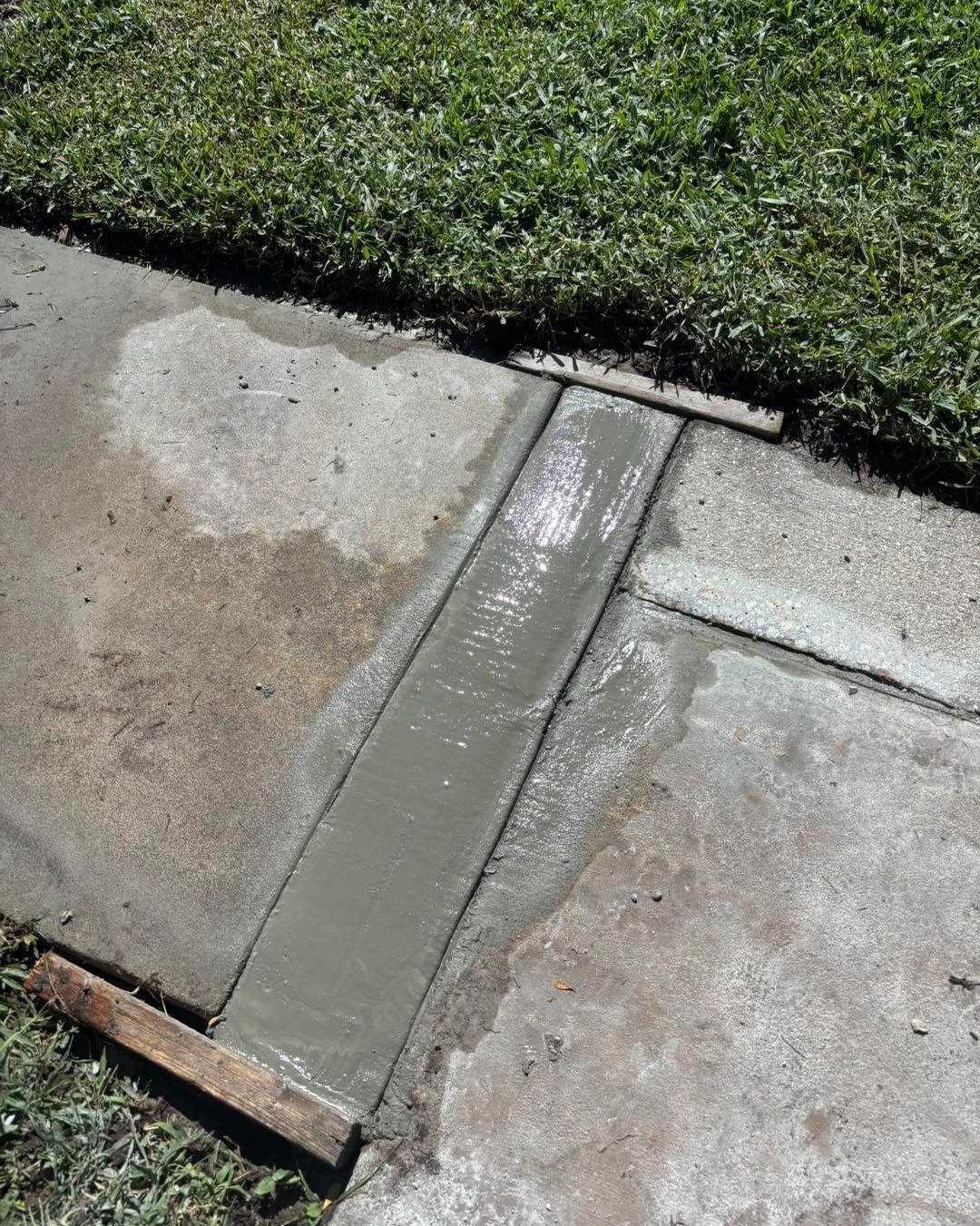 Close view of a narrow gray strip across a concrete walkway joint
