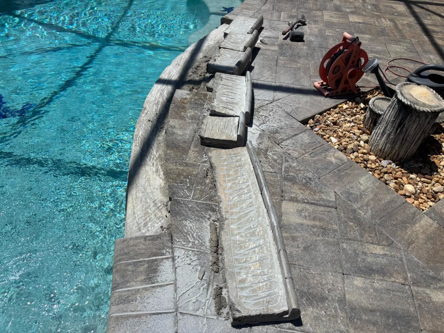 Lifted rectangular coping stones along a curved swimming pool edge