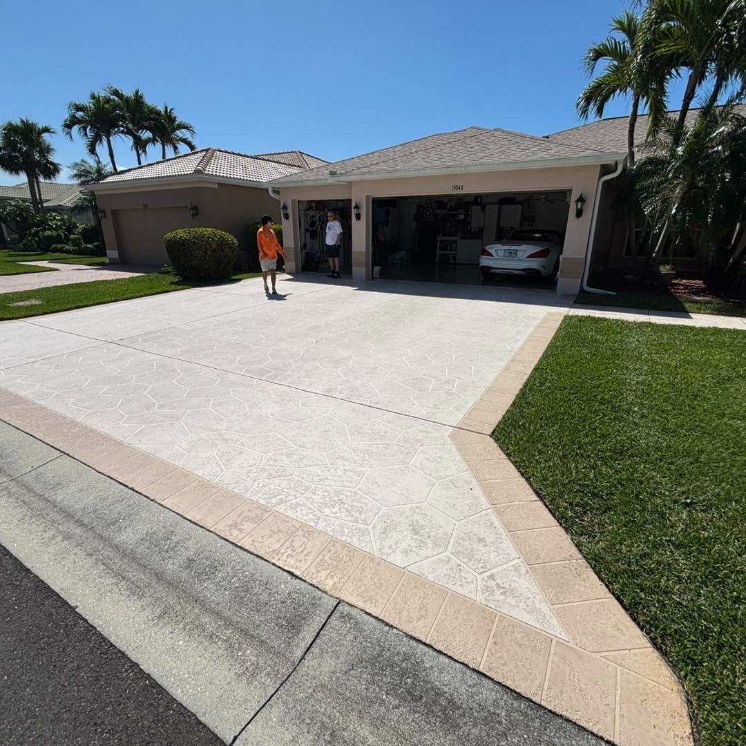 Pale driveway with contrasting border leading to an open residential garage