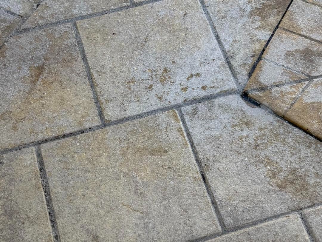 Close view of pale patterned paving with scattered surface marks