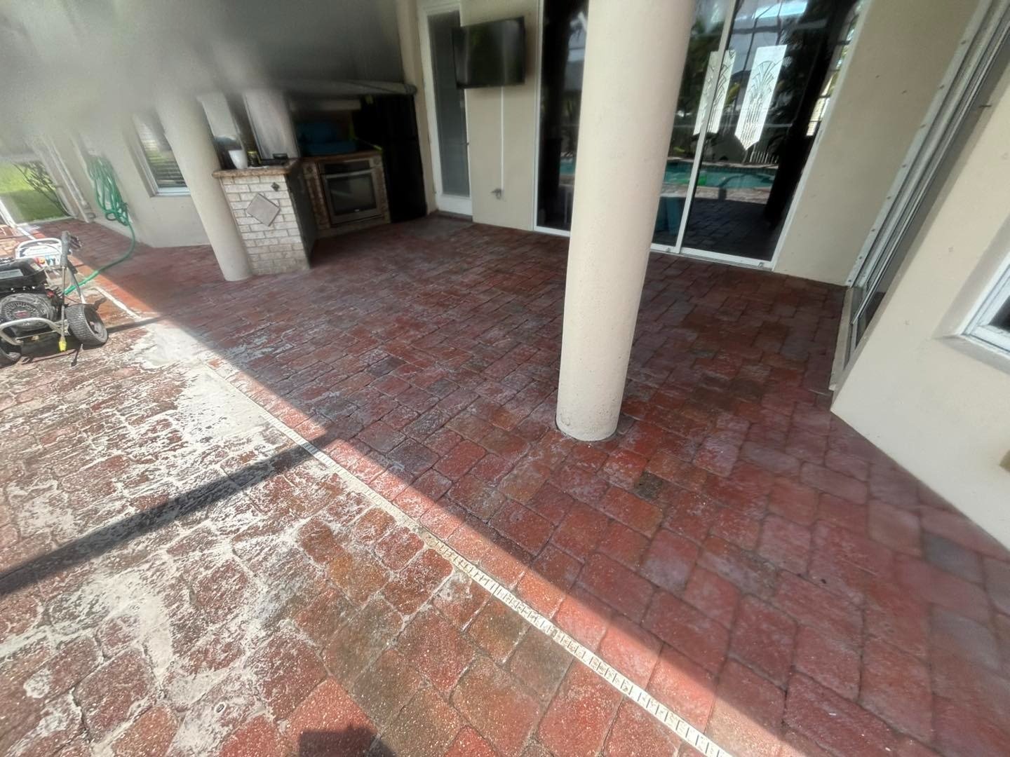 Red paver patio with pale surface residue beside a white column