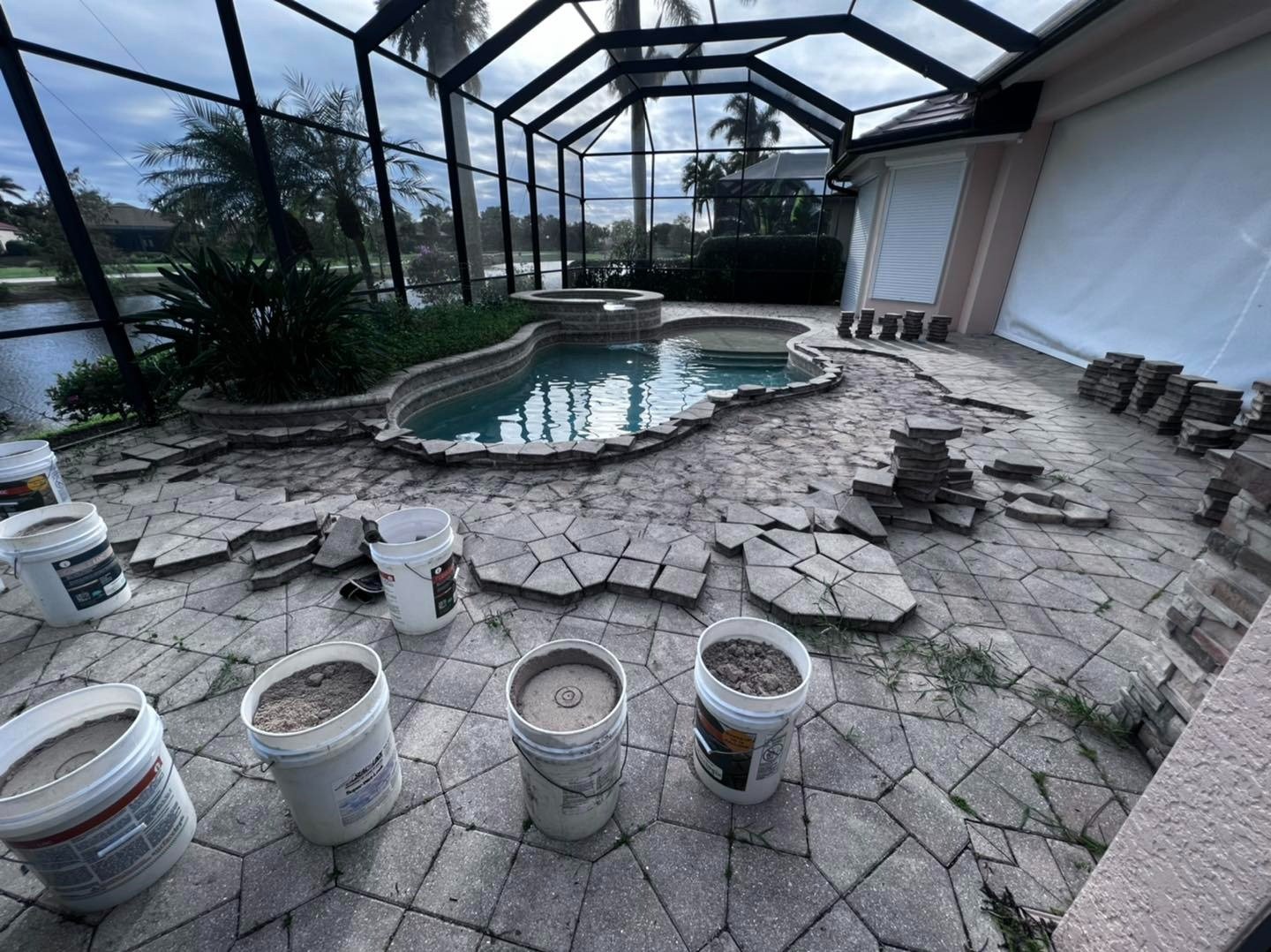 Screened pool deck with removed paving pieces and buckets