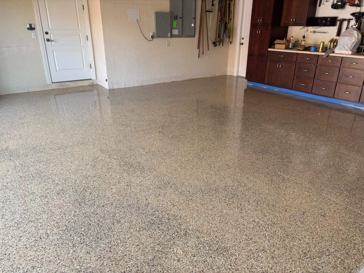 Speckled garage floor with cabinets along the back wall