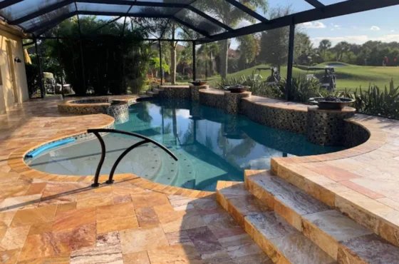 Warm brown pool deck with steps and handrail inside a screened enclosure