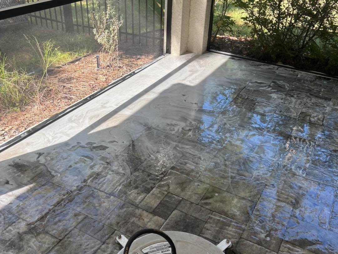 Wet gray paving beside a sliding door and screened patio
