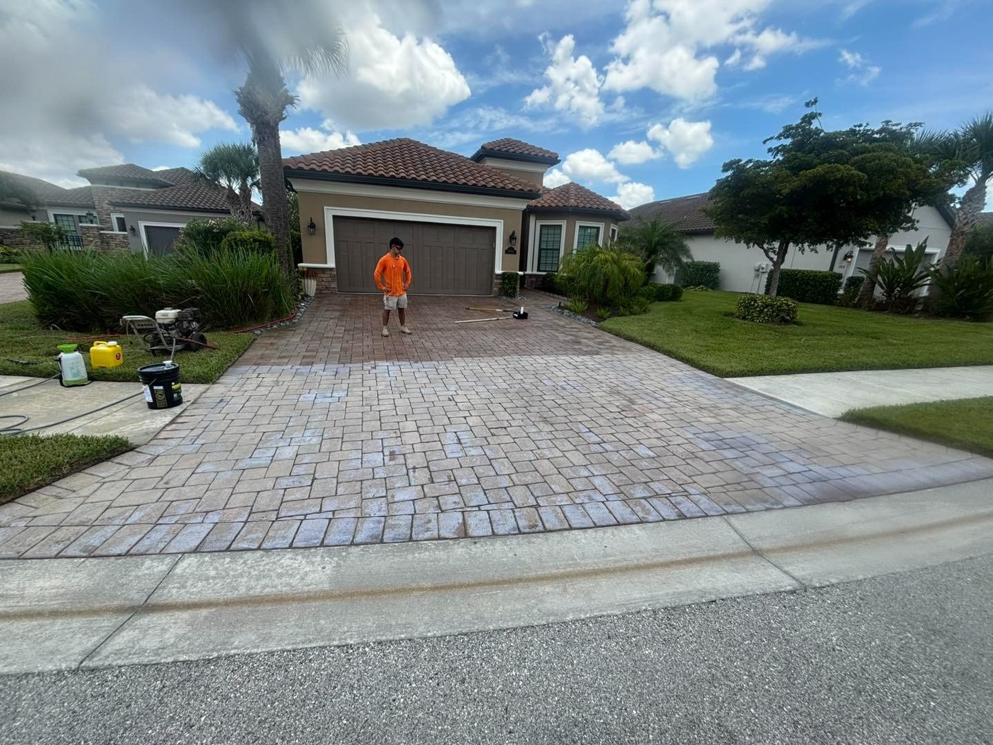 Wet patterned driveway leading to a garage with a worker near the entrance