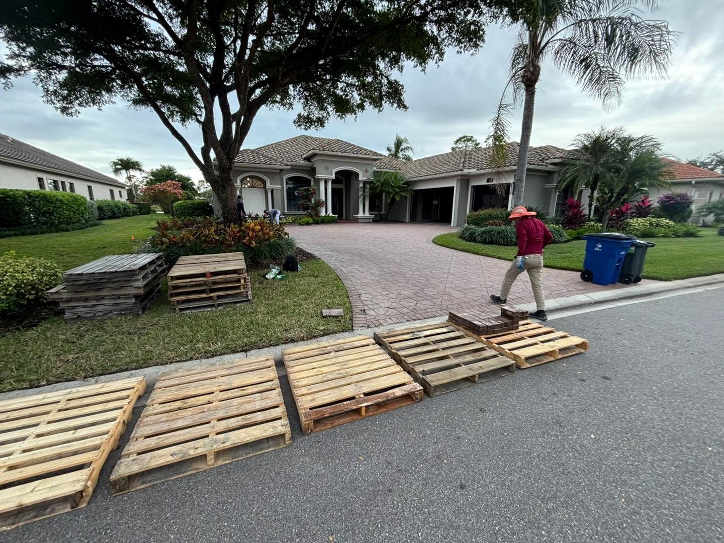 Wooden pallets beside the street in front of a curved driveway