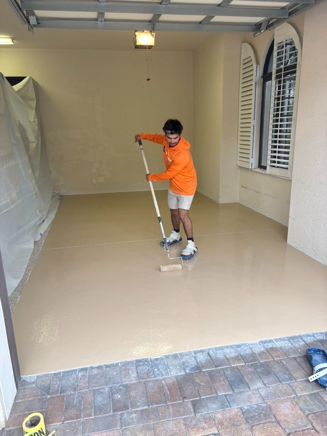 Worker rolling a coating onto a small garage floor