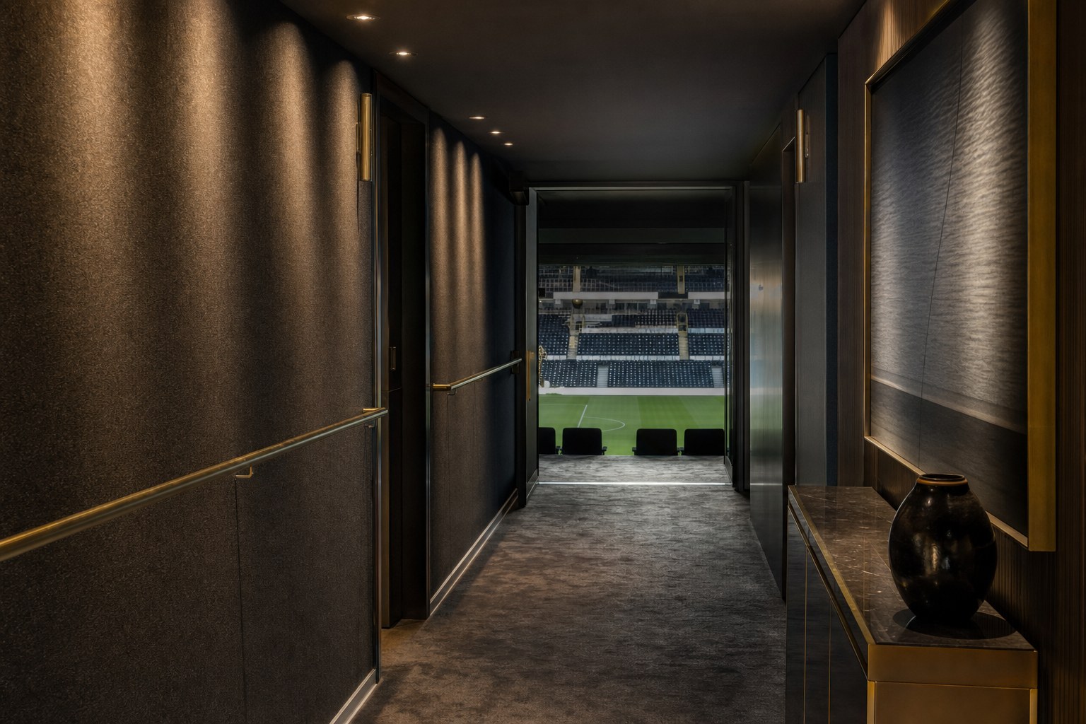 A private directors corridor leading towards a football pitch