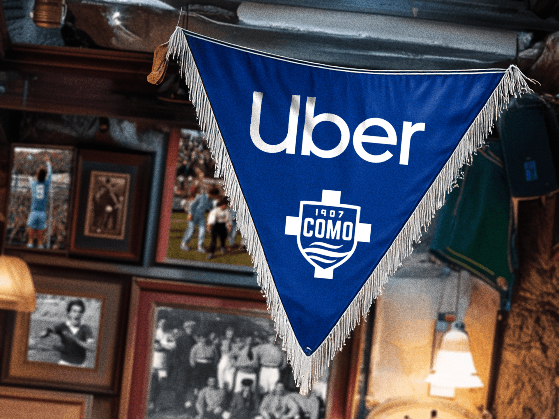 A Como 1907 and Uber pennant displayed inside a club space