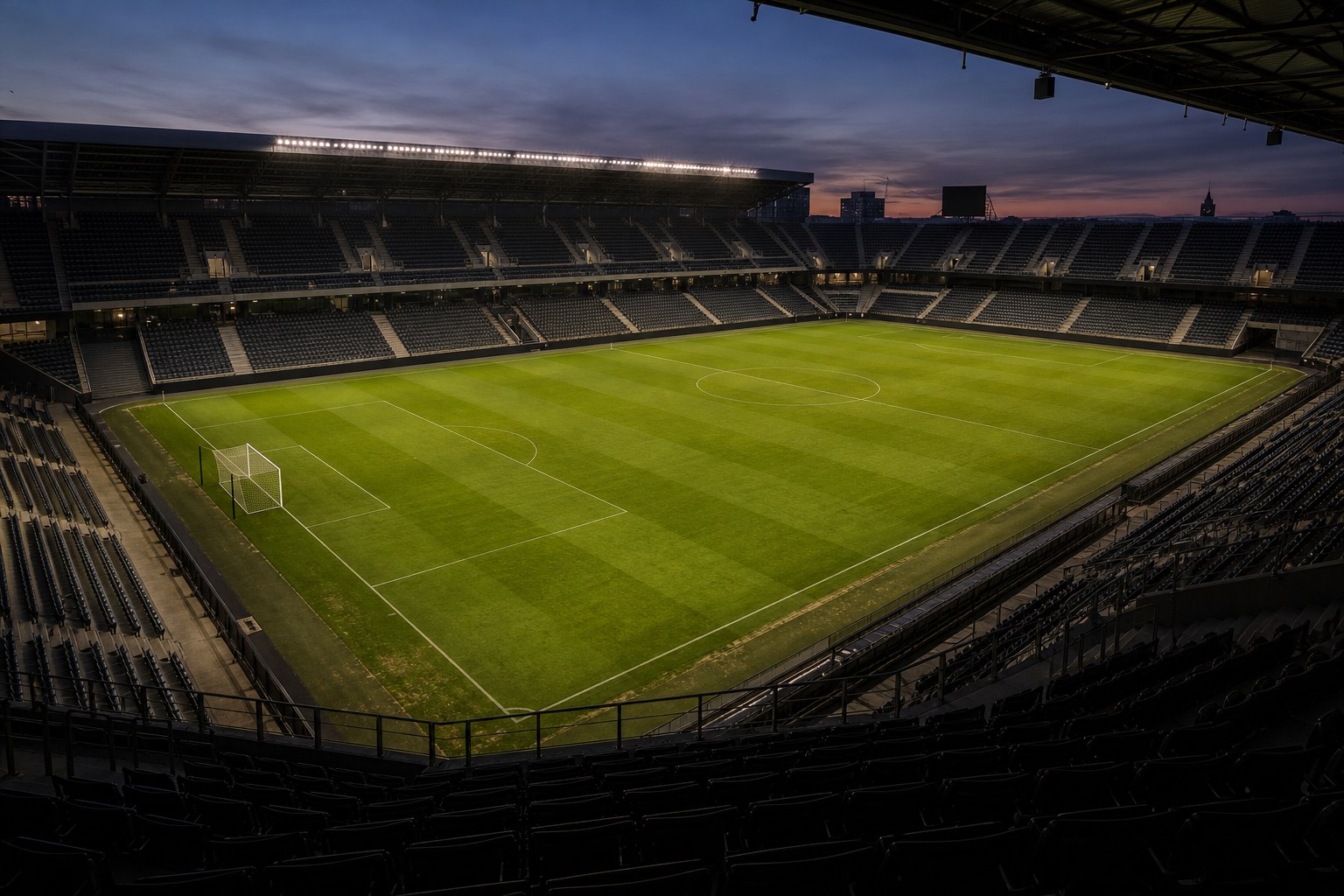 An empty football stadium at dusk viewed from the stands